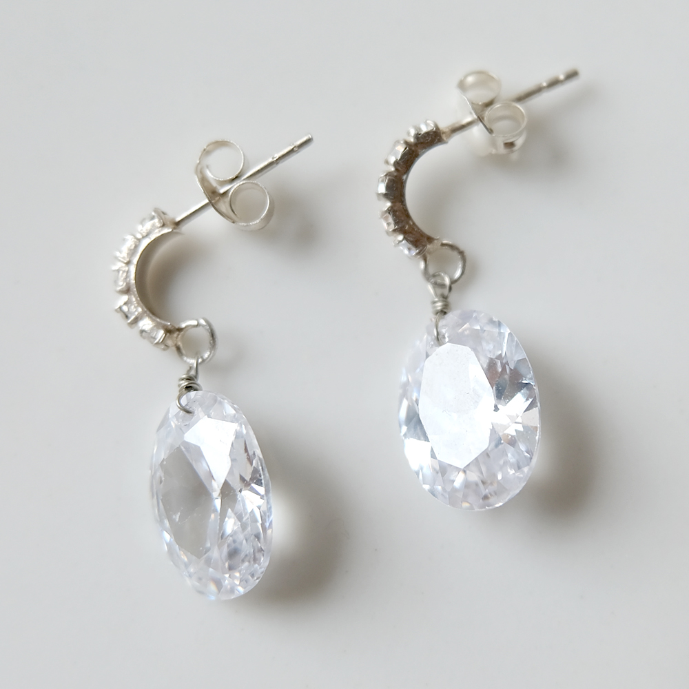 多面カットを施したオーバルのジルコニアを曲線ラインストーンのポストにセットしたSILVER925ピアスの画像