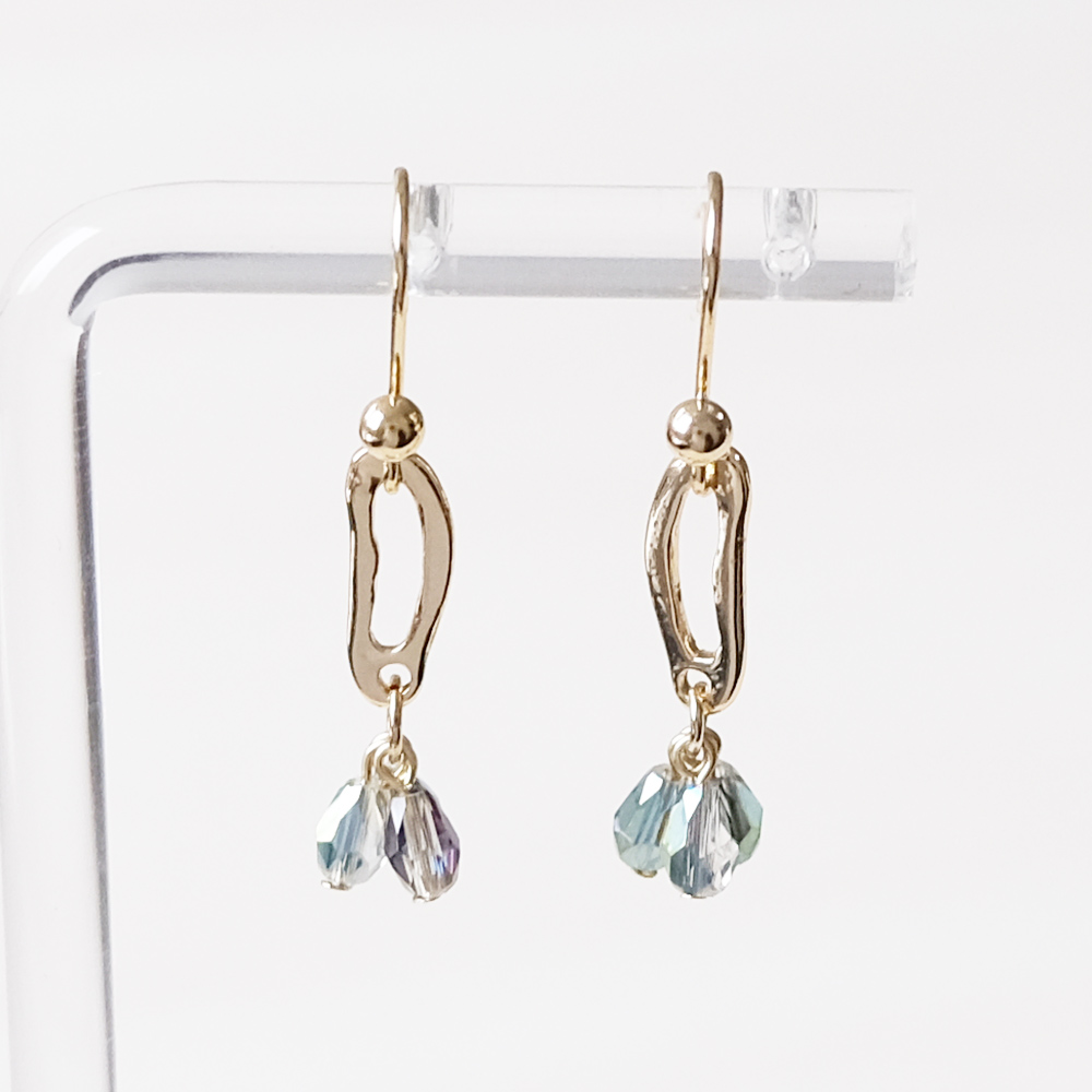 変形モチーフにガラスのドロップをセットしたピアスの画像