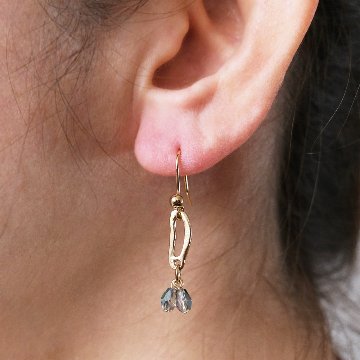 変形モチーフにガラスのドロップをセットしたピアスの画像