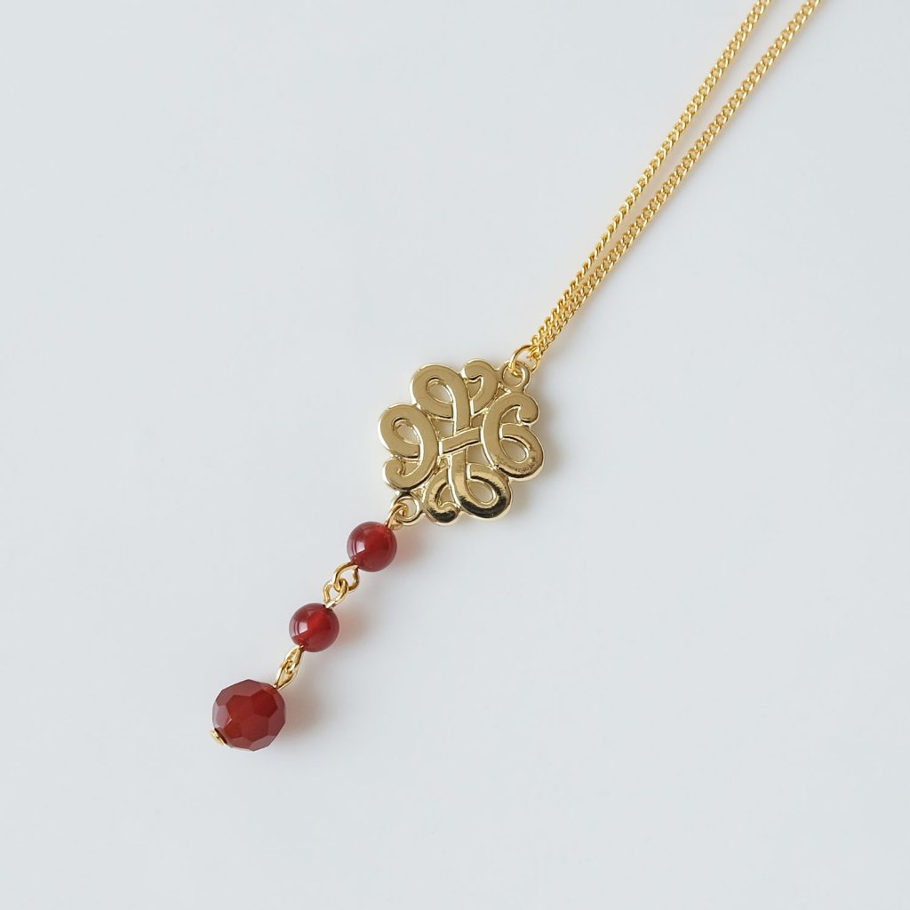 透かしメタルモチーフにカーネリアンを連ねたネックレスの画像