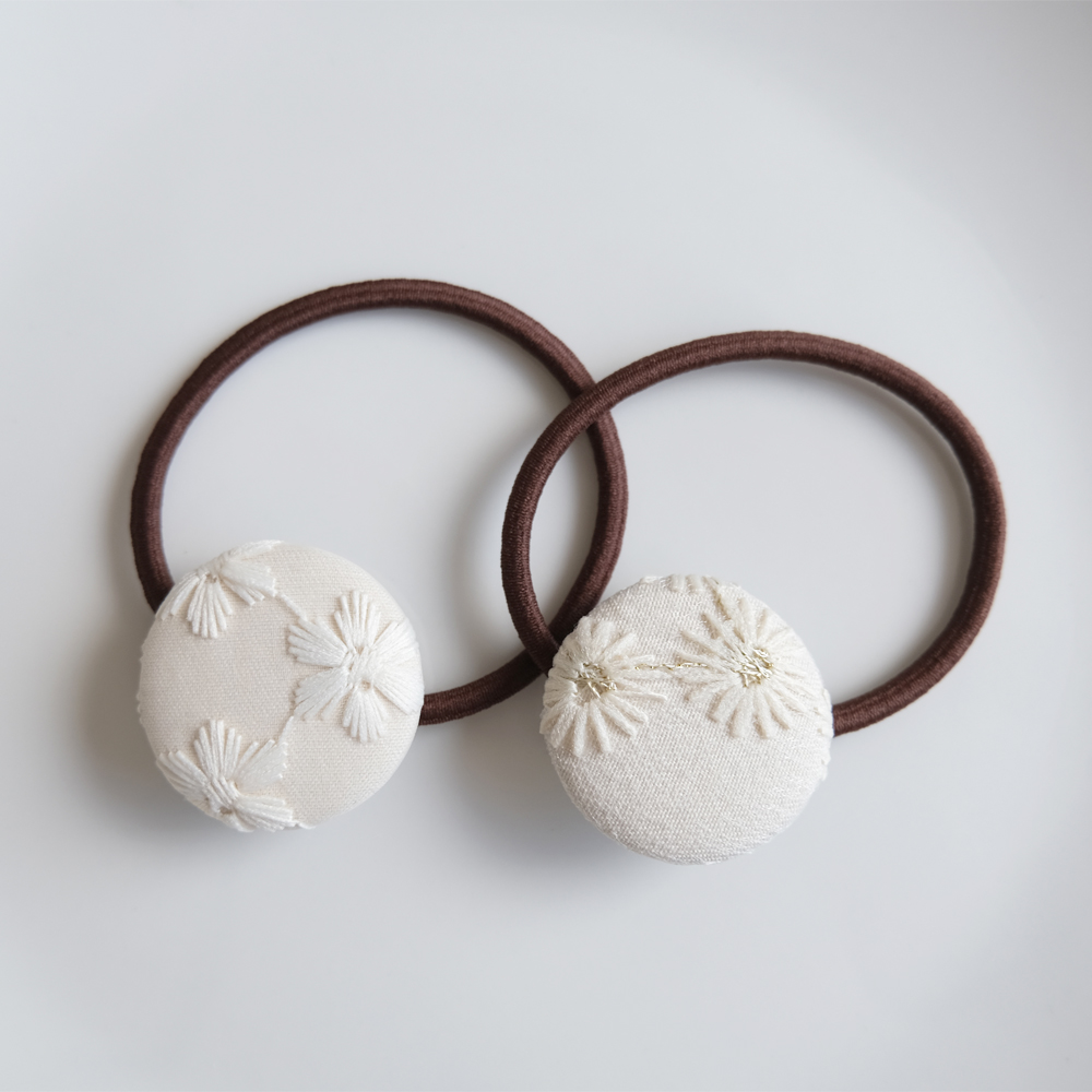 刺繍を施したくるみボタンのヘアゴムの画像